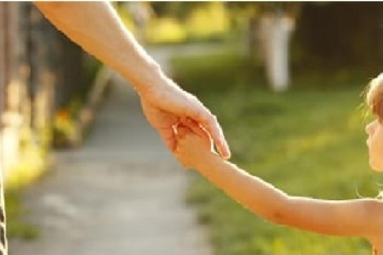 child holding hand with parent