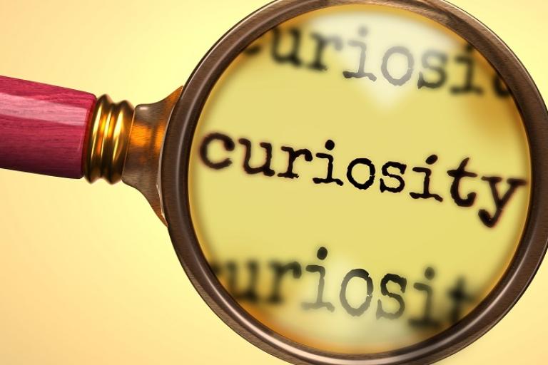 magnifying glass hovering over the word curiosity