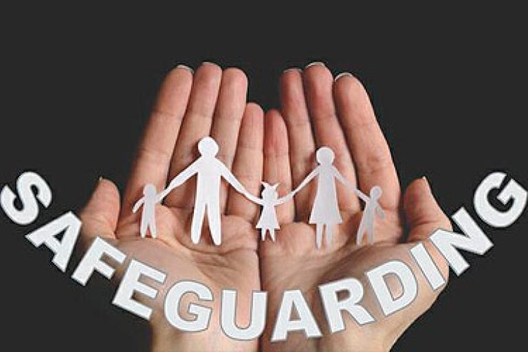 paper cutout of family and safeguarding in cupped hands