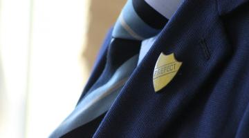 image of school uniform with 'perfect' badge pinned on blazer