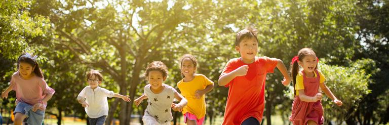 Mixed group children running in park